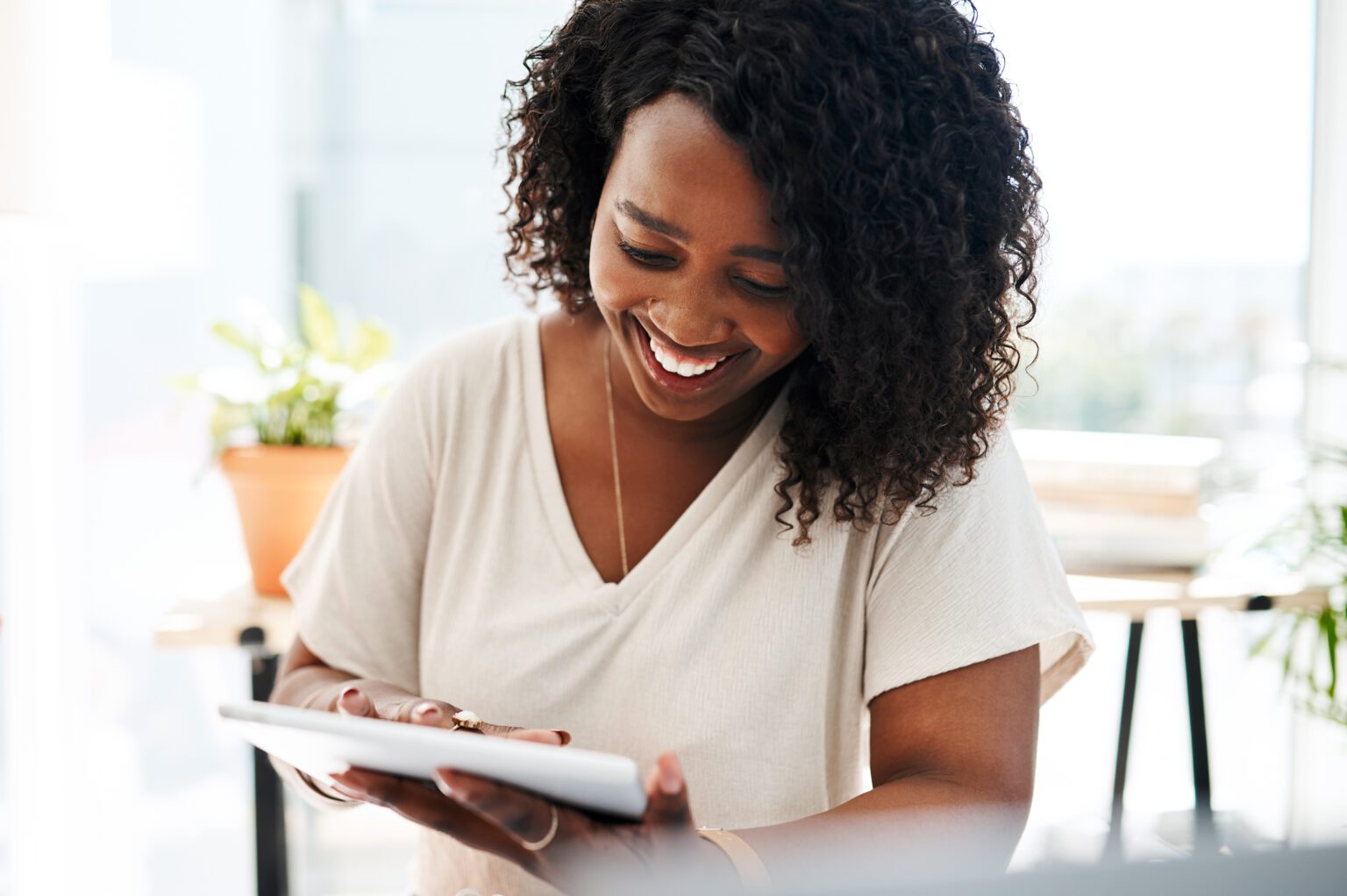 Young woman smiling while working on a tablet.