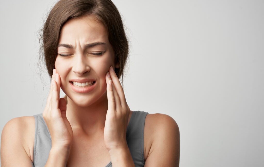 Young woman having jaw pain from teeth grinding in her sleep.